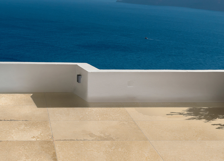 Terrasse mit großen Solnhofer Steinoptik Fliesen im Hintergrund Meer 